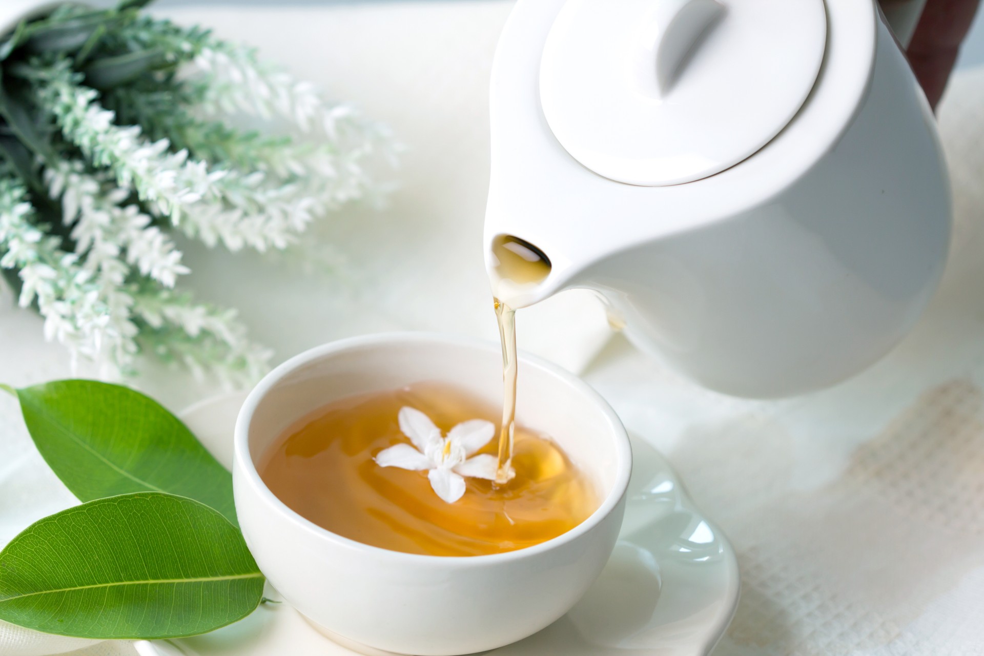 Close up pouring hot jasmine tea in a white tea cup ,  Tea ceremony time concept