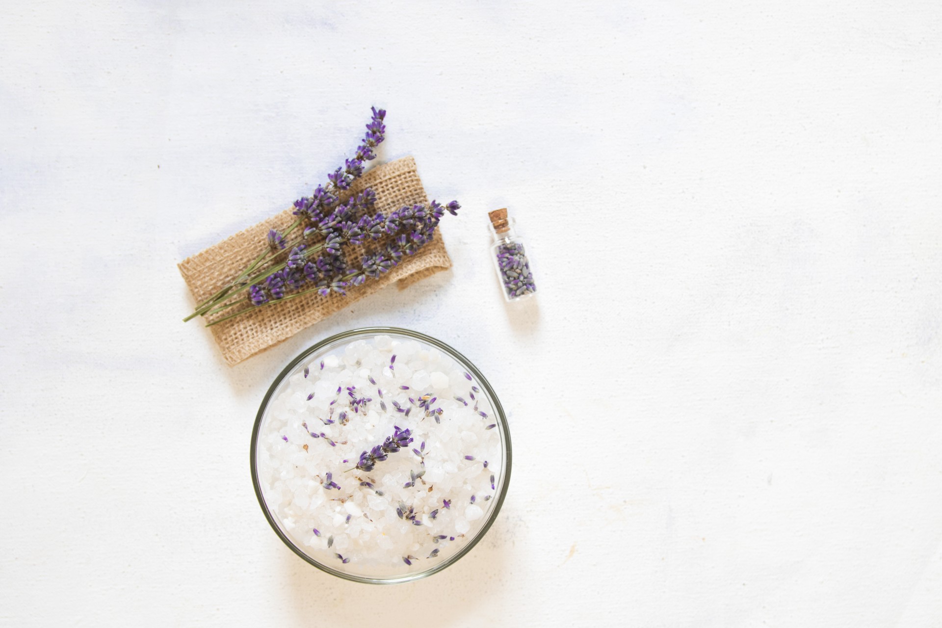 Natural herbal sea salt with aromatic lavender - perfect for relaxation. Cosmetic jars and bottles with salt, lavender flowers, bath bomb