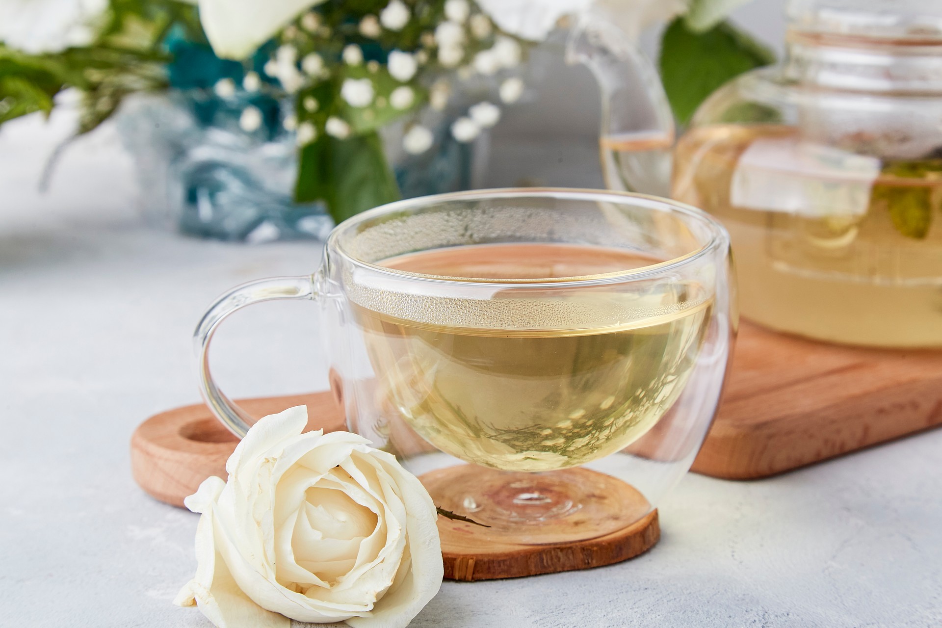 Herbal tea cup, aesthetic tea time in biophilic interior among white flowers. Feminine calm lifestyle, cozy home